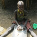For a meal karimojong girl granding seeds of wild fruit localy called (Ekoret)in Kaabong (Steven Ariong)