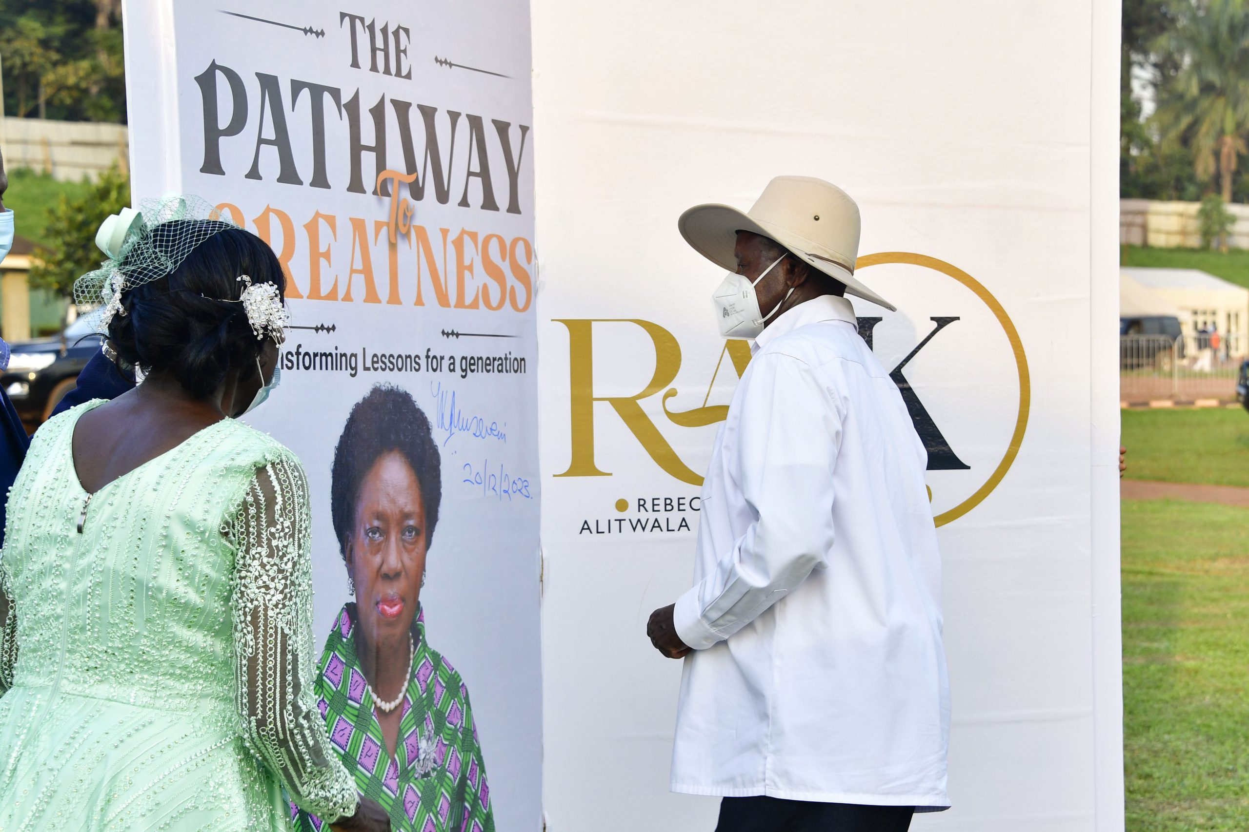 President Museveni signs on a dummy booklet as he launches Hon Rebecca Kadaga's book at Kololo on Wednesday as Hon Kadaga look on. PPU Photo (2)