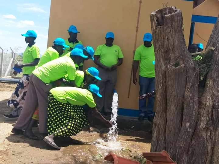 ater user committee of Kacheri opening water on Friday during the commisioning of piped water in Kacheri (photo by Steven Ariong)