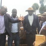 Elly Mucunguzi the Rubanda District Principal Assitant Secretary ( L) explains to Stephen Kamugisha ( R) as Patruick Abanaite the Muko LCIII chairman in hat looks on