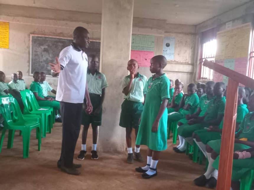 Students engaging with a teacher in a classroom setting at Ankole Times.